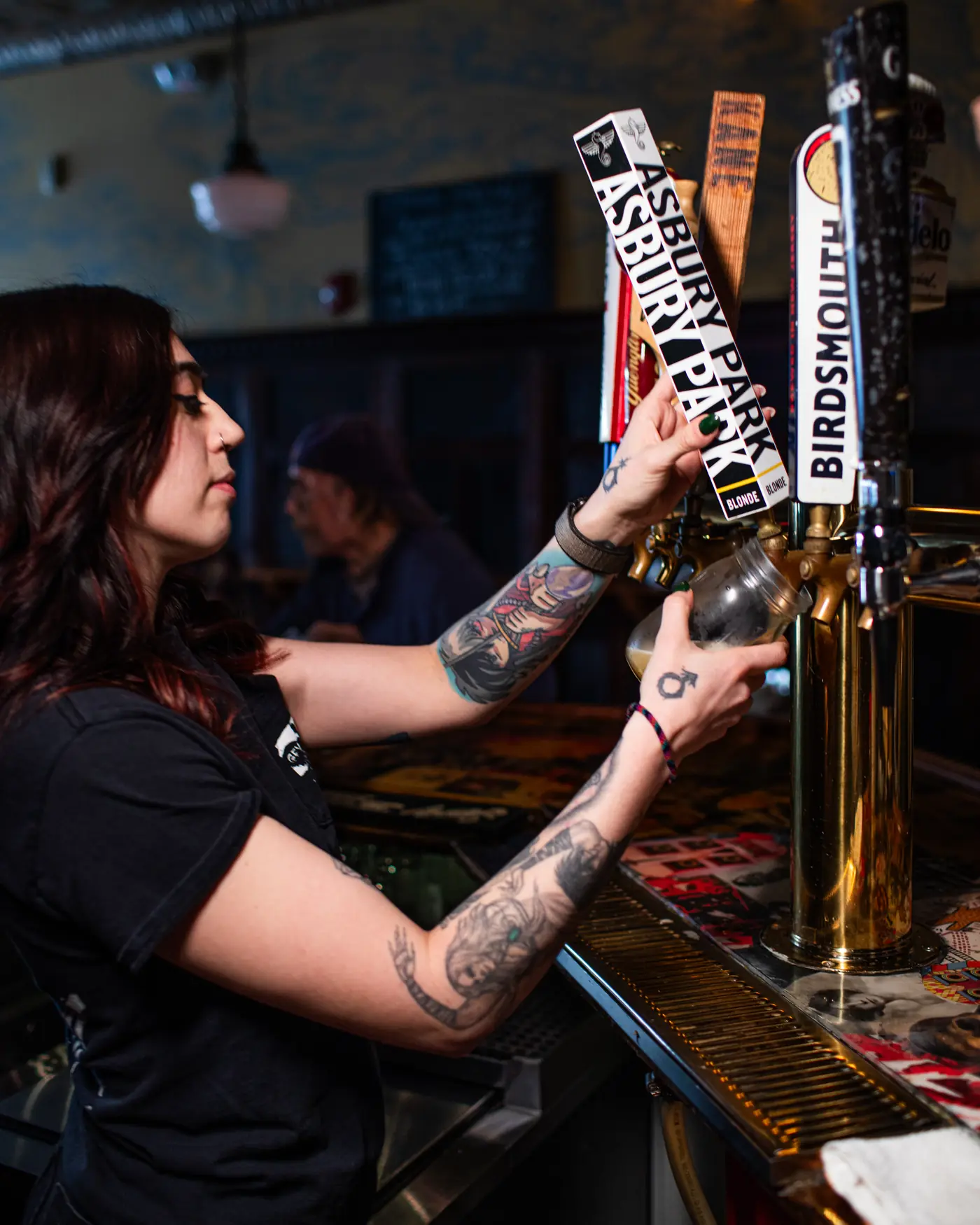 A bartender pulling a pint behind the bar at Bond Street.