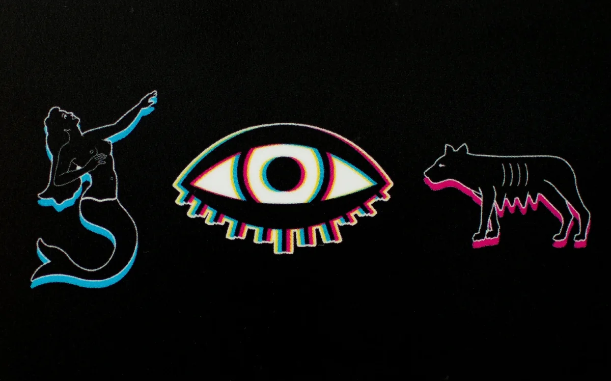 The Complex AP gift card — black, with Lotería's mermaid, the Bond Street eye and Capitoline's she-wolf printed in misregistered neon.